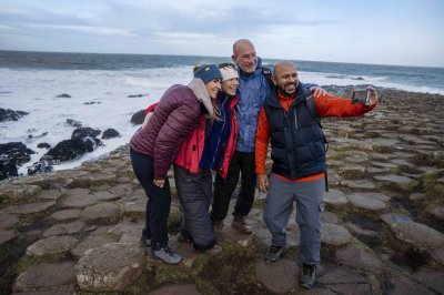 Giants Causeway Courtesy of Tourism Northern Ireland four people standing on rocky landscape while taking photo